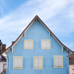 maison bleue aux volets blancs sur fond de ciel bleu