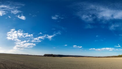 Clear blue sky with white clouds and a hint of snow