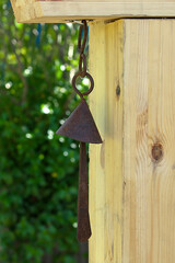 a rusty tin bell on a wooden pole