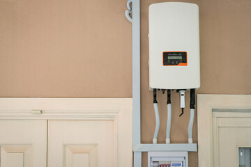 Solar inverter mounted on the wall of a residential home. Solar energy or go green concept.