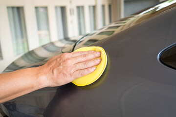 Man waxing a wax or polishing car, close up view. Car care concept.