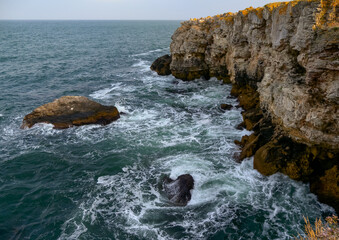 Seascape on the Black Sea, high steep stone coast with inaccessible rocks near the village of Tyulenovo, Bulgaria