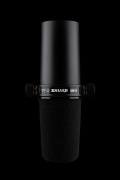 Samara, Russia - December 24, 2023: Shure SM7B microphone isolated on a black background. Black dynamic microphone front view.