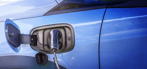 Blue electric car with charging plug