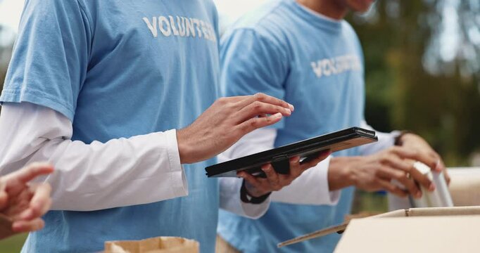 Hands, tablet and outdoor for charity in volunteer group, package and scroll with donation in community. People, boxes and digital touchscreen in park, app and solidarity for social responsibility