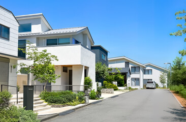 並んだ家の白い壁と青い空が爽やかな住宅街