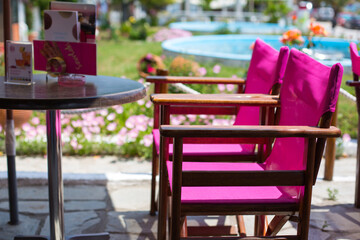 Two bright purple chairs in a row and table at the cafe