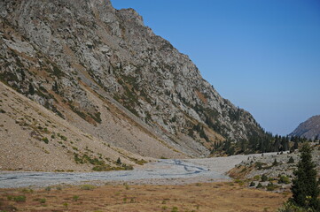 Mountains with large rocky slopes and vegetation.
