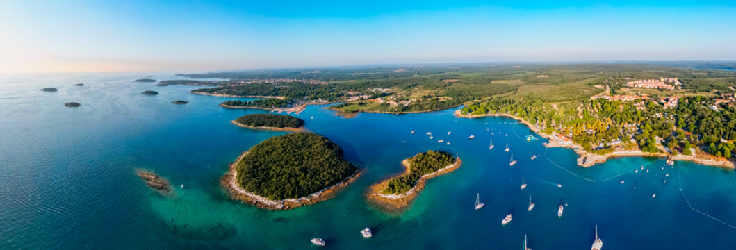 Aerial panorama of beautiful Adriatic coastline near the town of  Vrsar, Istria peninsula, Croatia. Tourist boats off the coast with crystal clear water. Island Cavata, island Salamun