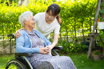 Fototapeta premium Caregiver help and care Asian senior woman patient sitting on wheelchair at nursing hospital ward, healthy strong medical.