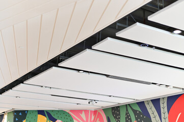 Modern ceiling design with acoustic panels and colorful wall art