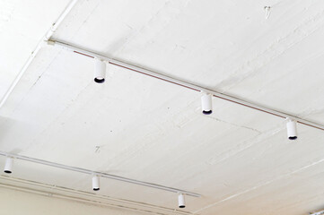 Ceiling lights illuminate modern space with clean, minimalist design. bright fixtures create sense of openness and clarity.