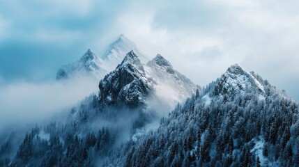 Breathtaking view of majestic snow-covered mountains with misty clouds, creating a serene and captivating winter landscape.