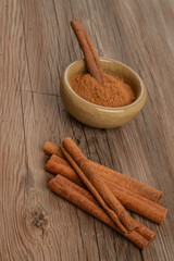 cinnamon sticks and powder on wooden table