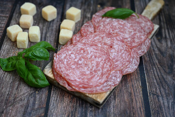 Slices Of  Traditional Italian antipasti salame Milano, parmesan cheese   on a wooden  cutting board.