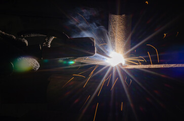 worker welding metal with sparks.