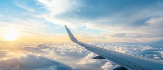 Obraz premium An airplane wing silhouette against the sky, adorned with clouds in the foreground and the sun setting in the distance
