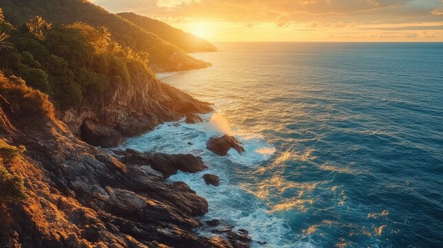 The rocky coastline of Krating Cape in Phuket, where waves crash against the cliffs under the golden light of sunset.