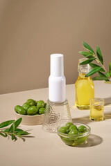 Bowls of fresh olives decorated with glass bottles of olive oil on light brown background. An empty white bottle displayed in the middle for design. Mockup bottle for advertising cosmetic