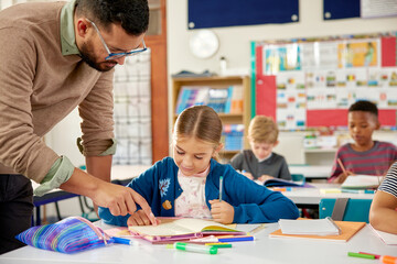 Teacher helping elementary student in classroom