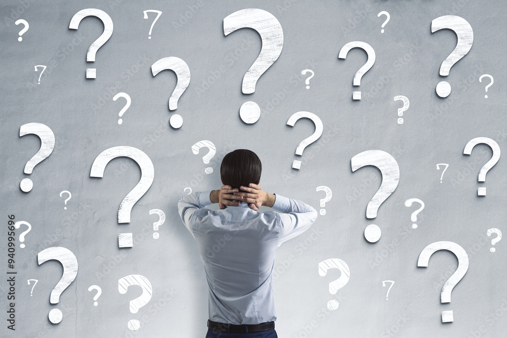 Poster Back view of young male on concrete wall background with question marks. Solution and confusion concept.