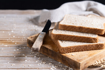 Healthy wholemeal bread slices on rustic wooden table. Copy space