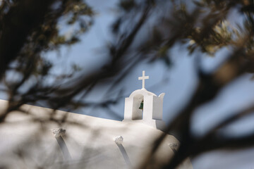 White Cycladic Church in Oia Viewed Through Olive Tree Branches on Santorini
