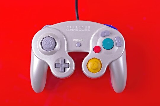 Neu-Ulm, bavaria, Germany - August,  26, 2024:  Nintendo Gamecube game controller  isolated on red background.	