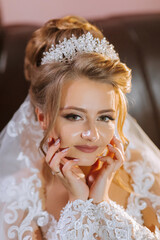A woman wearing a tiara and a white dress. She is smiling and looking at the camera
