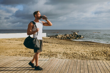 Full body young strong athletic toned fit sportsman man he wear sports clothes bag drink protein...