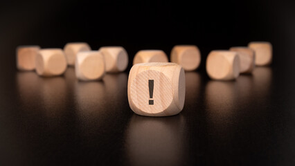 concentrate on a wooden block featuring an exclamation mark symbol, signifying urgency