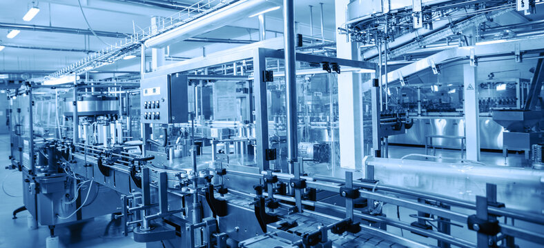 Modern automated factory assembly line for bottling beverages. Advanced industrial equipment and machinery emphasize efficiency, automation, and high-tech manufacturing processes in sterile