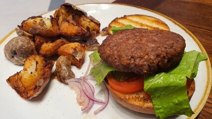 Open Burger on a Plate with Side of Crispy Potatoes – A Delicious Meal