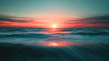 A vibrant orange and pink sunset over a calm, blue ocean, with long exposure creating a dreamy, abstract effect.