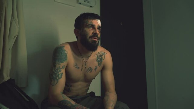 Handsome guy with a naked body and tattoos with a phone