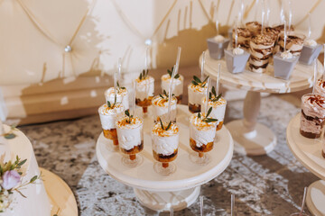 A table with a variety of desserts, including cupcakes and cakes, arranged on a white platter