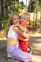 a young girl hugging a young boy on the back of a bench.