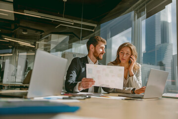 Two skilled professionals are collaborating closely in a modern office environment, discussing important data