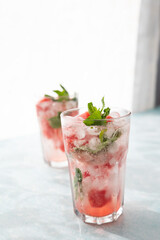 Homemade summer watermelon lemonade with ice and mint on light background, place for text