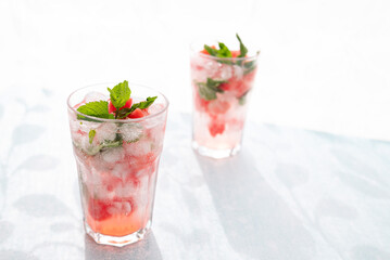 Homemade summer watermelon lemonade with ice and mint on light background, place for text