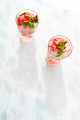 Homemade summer watermelon lemonade with ice and mint on light background, place for text
