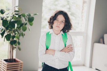 Photo of charming adorable nice boy school kid wearing white shirt going to school 1st september room indoors