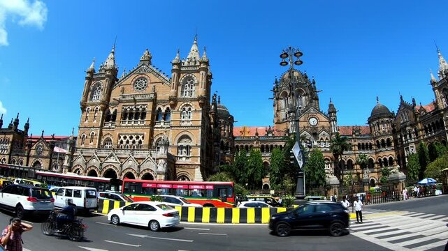 CST, Mumbai, Maharashtra, India - 13th June 2022 - Timelapse close shot of CST Railway Station with fast moving vehicles in the foreground.
