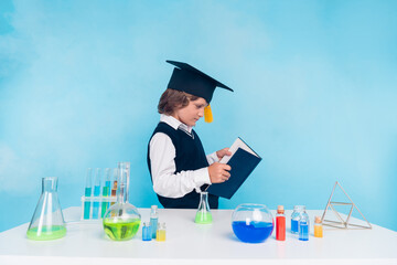 Photo of diligent intelligent boy read learn chemistry subject research isolated on blue color background