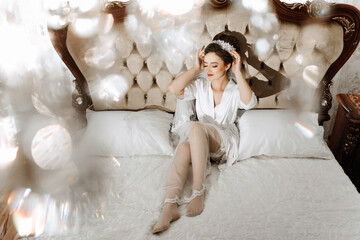 A woman in a white dress is sitting on a bed