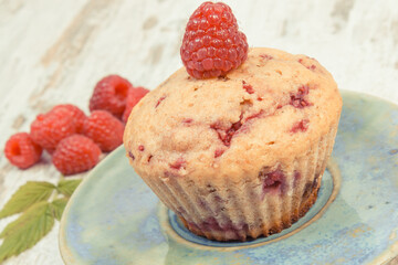 Fresh baked muffin with raspberries and chocolate. Delicious dessert