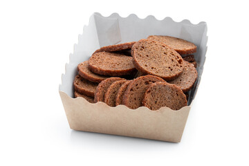 Rye bread crackers in paper bowl isolated on white background