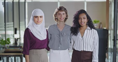 Indian Asian happy young adult gen z proud women lady wear hijab scarf look cam indoor work place cute teen mix girls curly hair expert female intern staff group team do pose enjoy job office day time