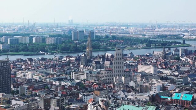Cityscape of Antwerp showcases the scheldt river flowing gently from left to right. The onze lieve Vrouwekathedraal Cathedral spire stands out in the urban skyline