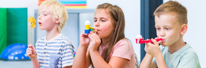 Group of young children making breathing exercises during physical therapy session. Kids in group...